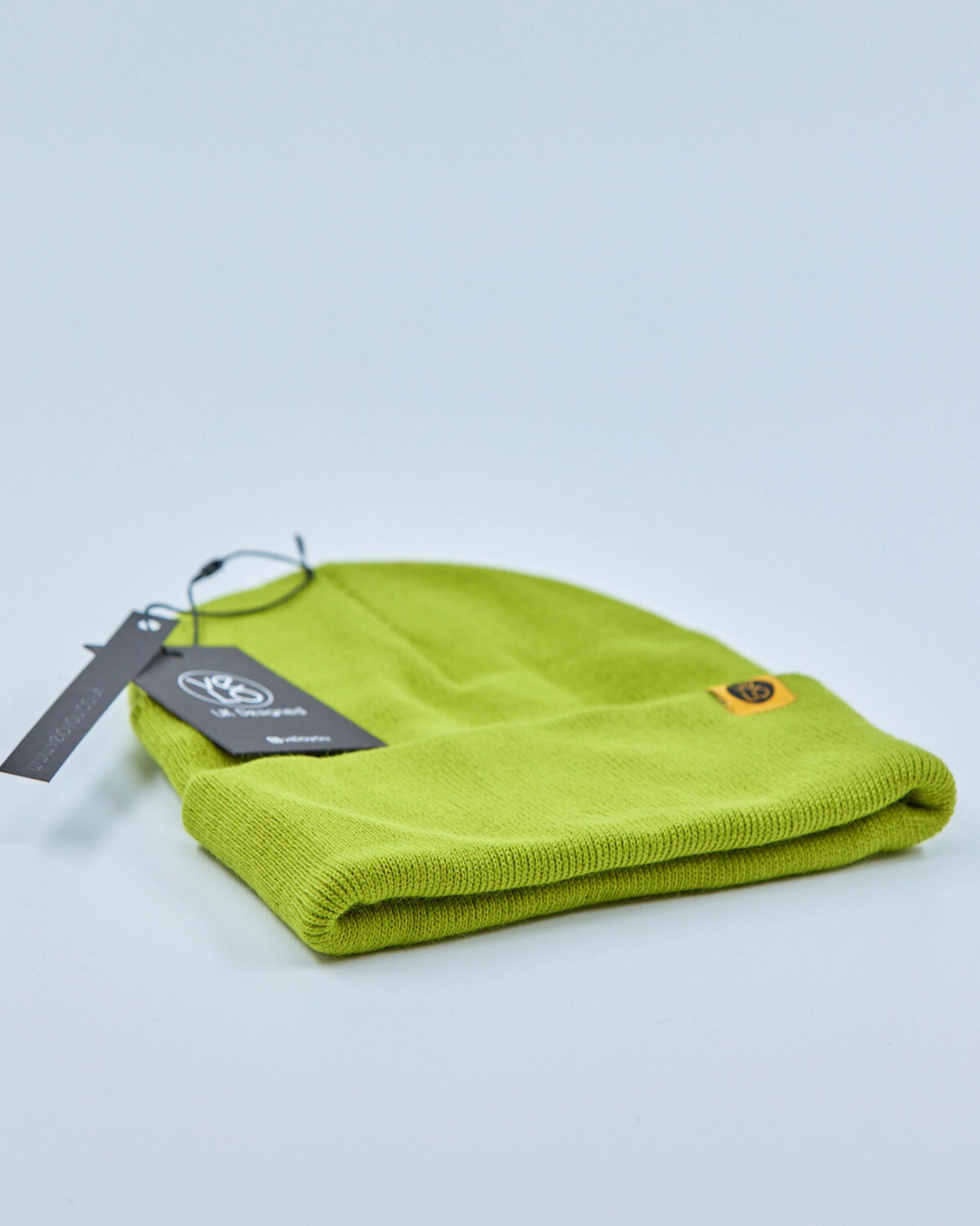 Green beanie with a tag on a light gray background