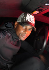 Person wearing Rust & Rich Gray Trucker Hat inside a vehicle with red interior lighting