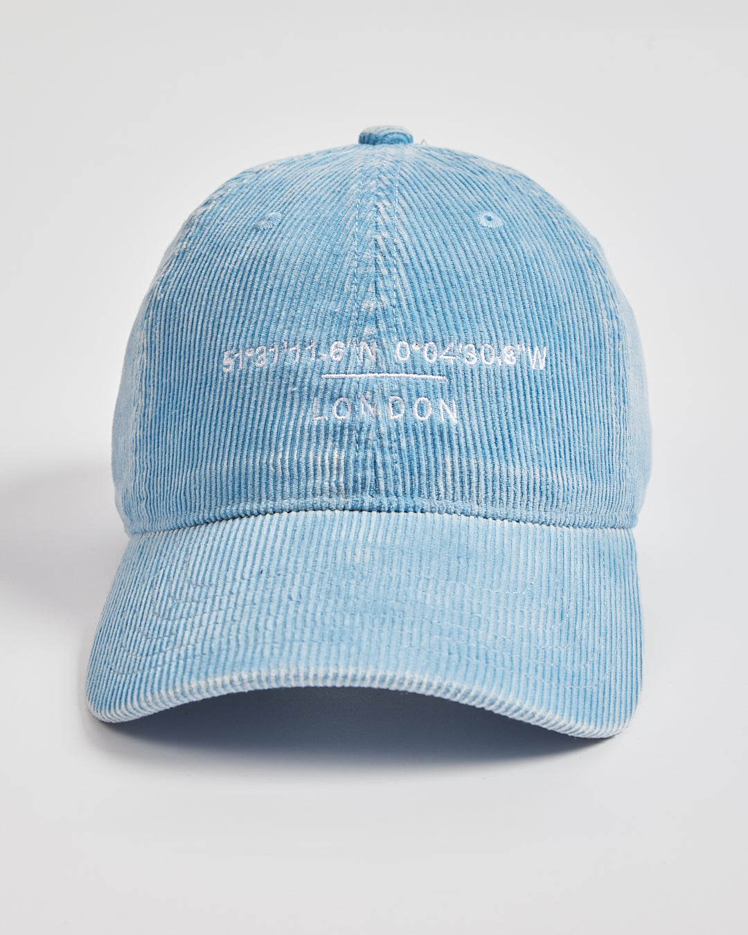 Light blue corduroy cap with white text on a light gray background