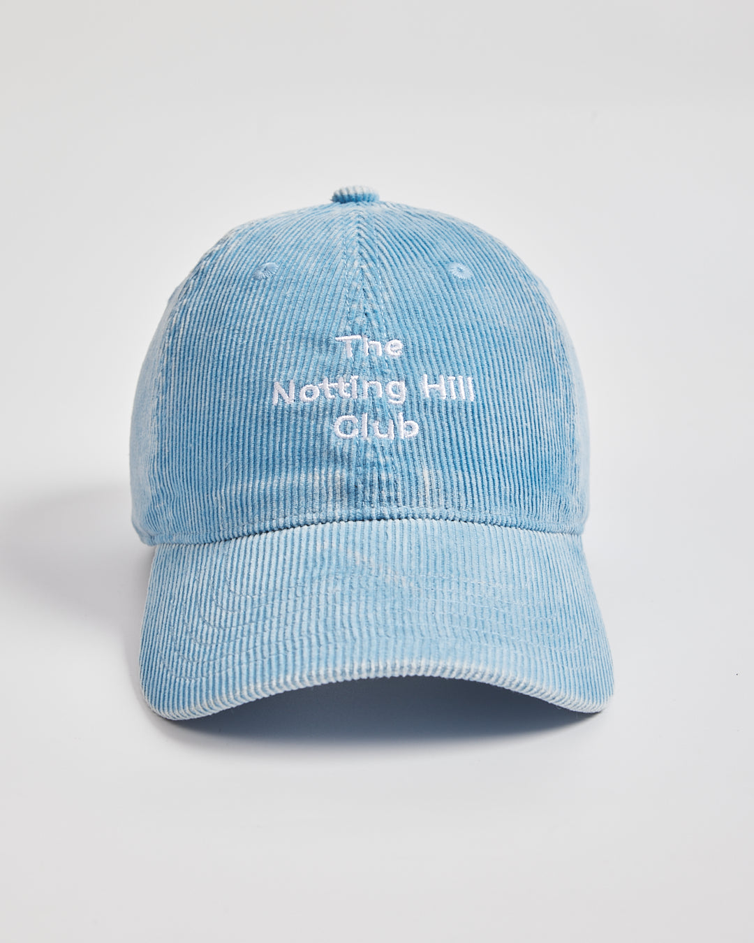 Light blue cap with 'The Notting Hill Club' text on a light gray background