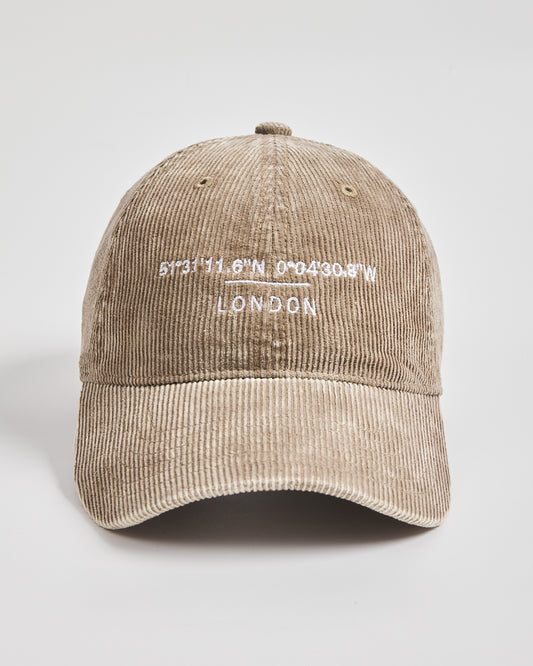 Beige corduroy cap with white text on a light gray background