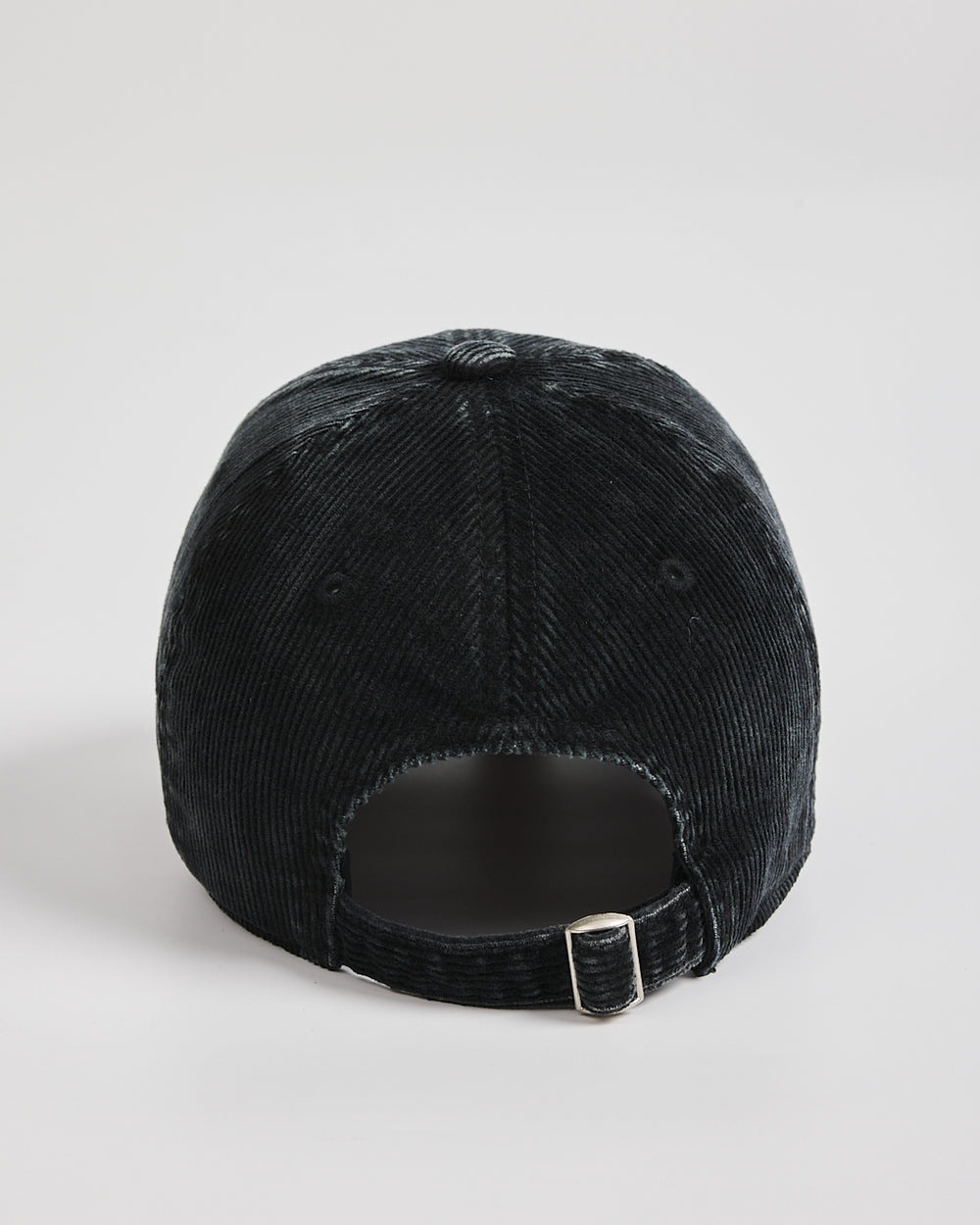 Black corduroy cap on a light gray background