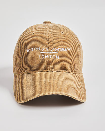 Camel corduroy cap with 'London' and coordinates embroidered on a light gray background