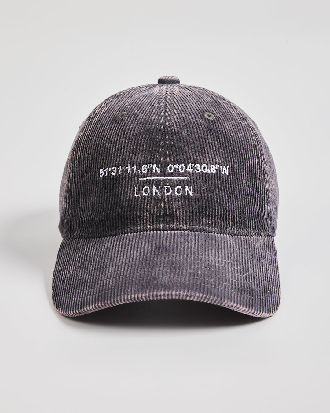 Gray corduroy cap with embroidered text on a light gray background