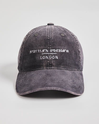 Gray corduroy cap with embroidered text on a light gray background
