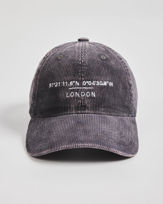 Gray corduroy cap with embroidered text on a light gray background