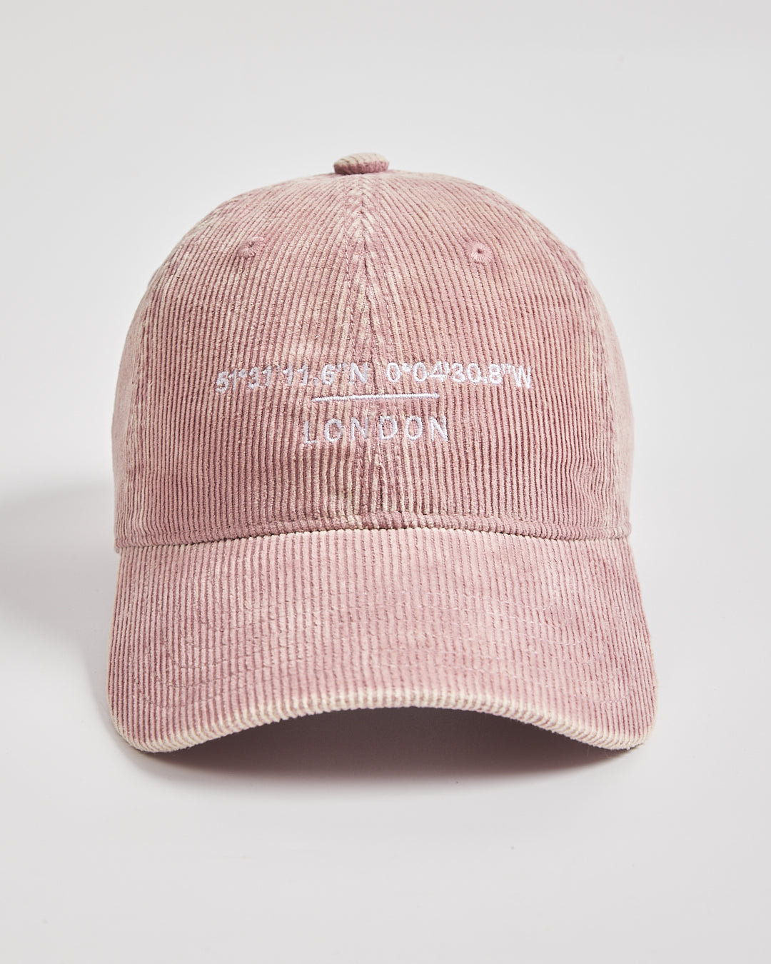 Pink corduroy cap with text on a light gray background