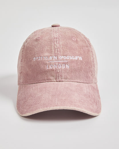 Pink corduroy cap with text on a light gray background