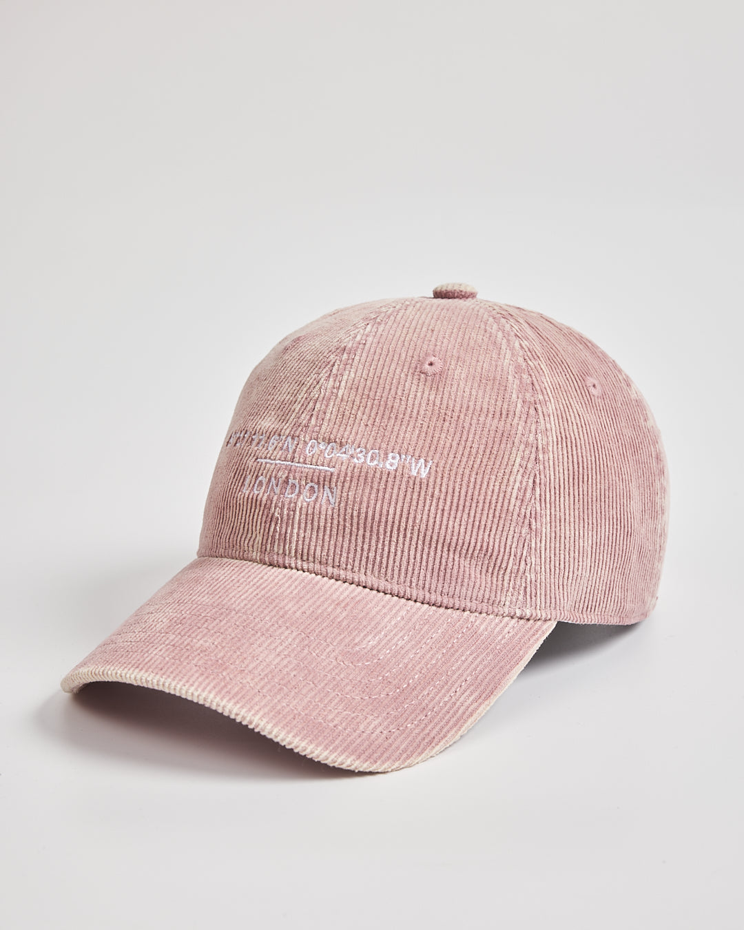 Pink corduroy cap with branding on a light gray background