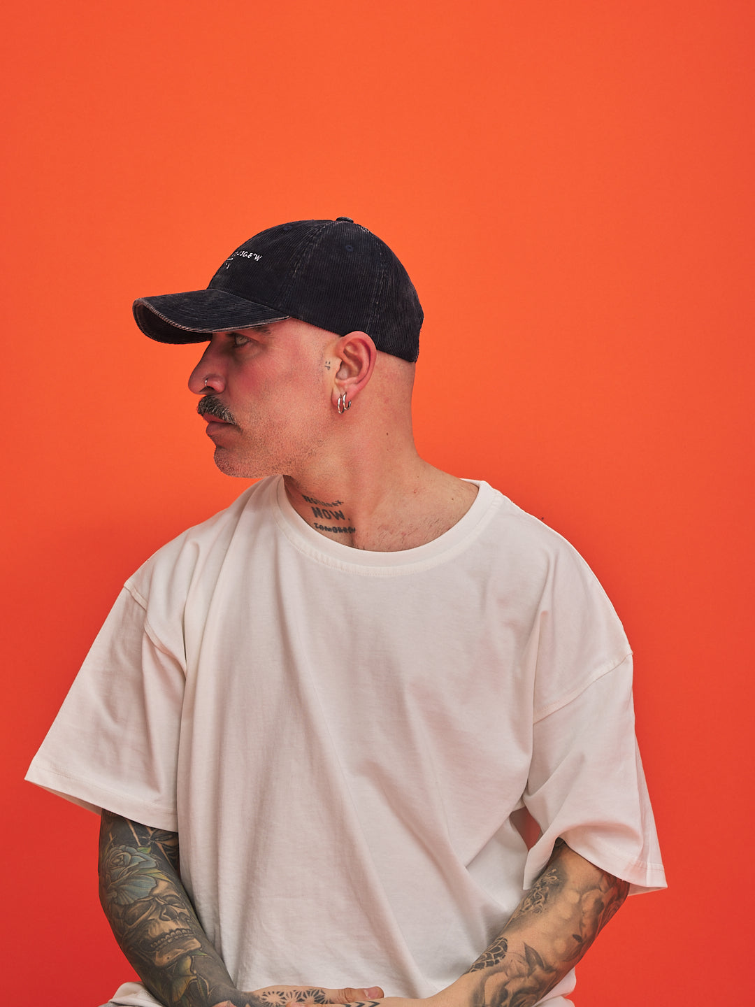 Man showing right side showing the left view of navy cap