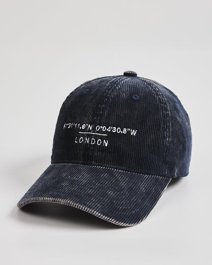 Navy cap with 'London' and coordinates on a light gray background