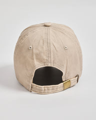 Beige cap with a gold tag on a light gray background