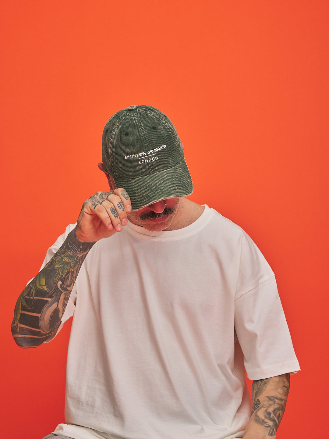 Person wearing a green cap with text on an orange background