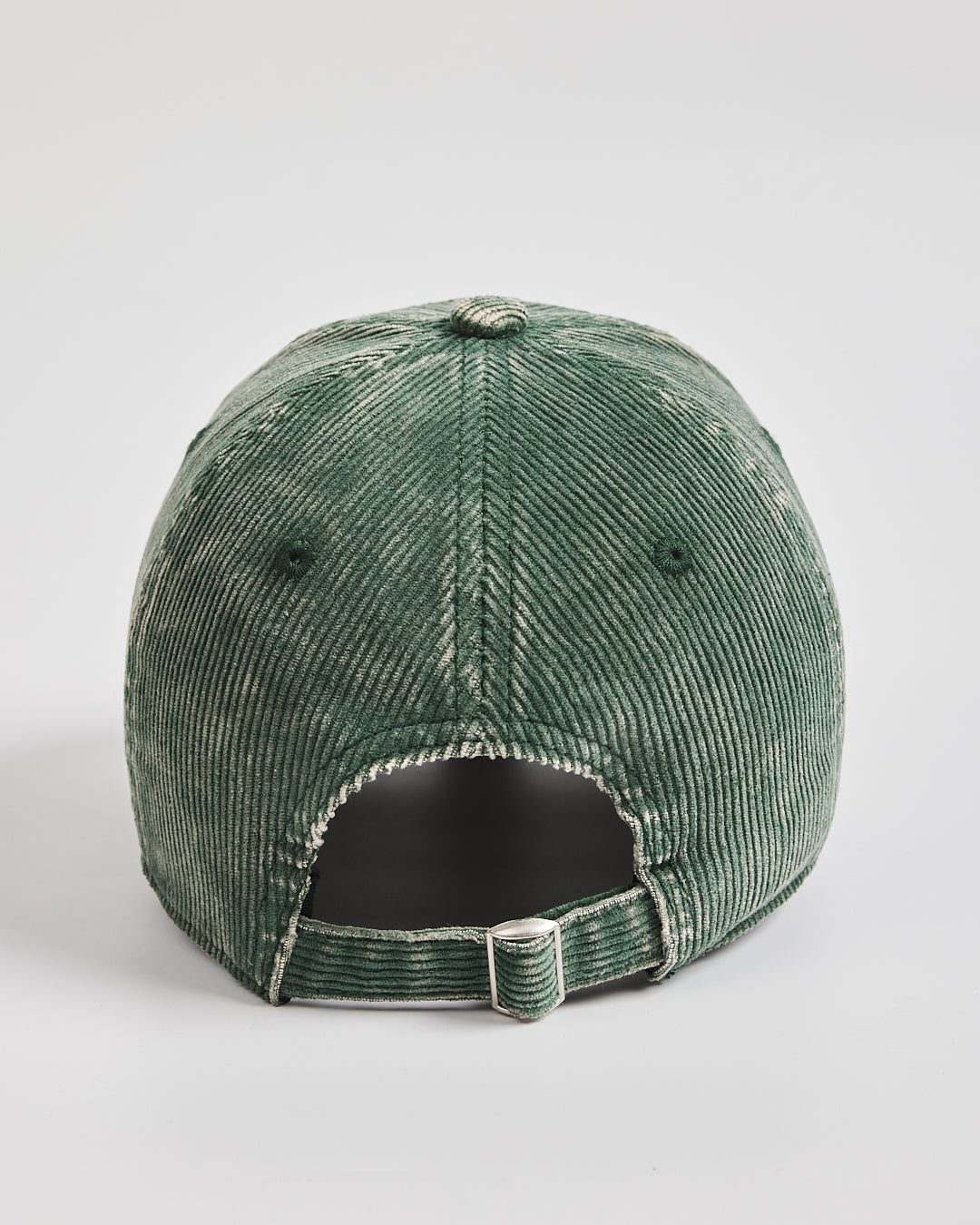 Green corduroy cap on a light gray background