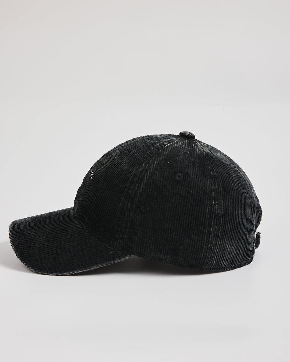 Black corduroy cap on a light gray background