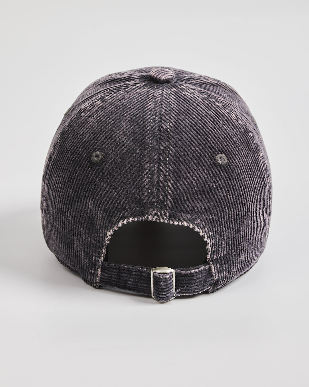 Black corduroy cap on a light gray background