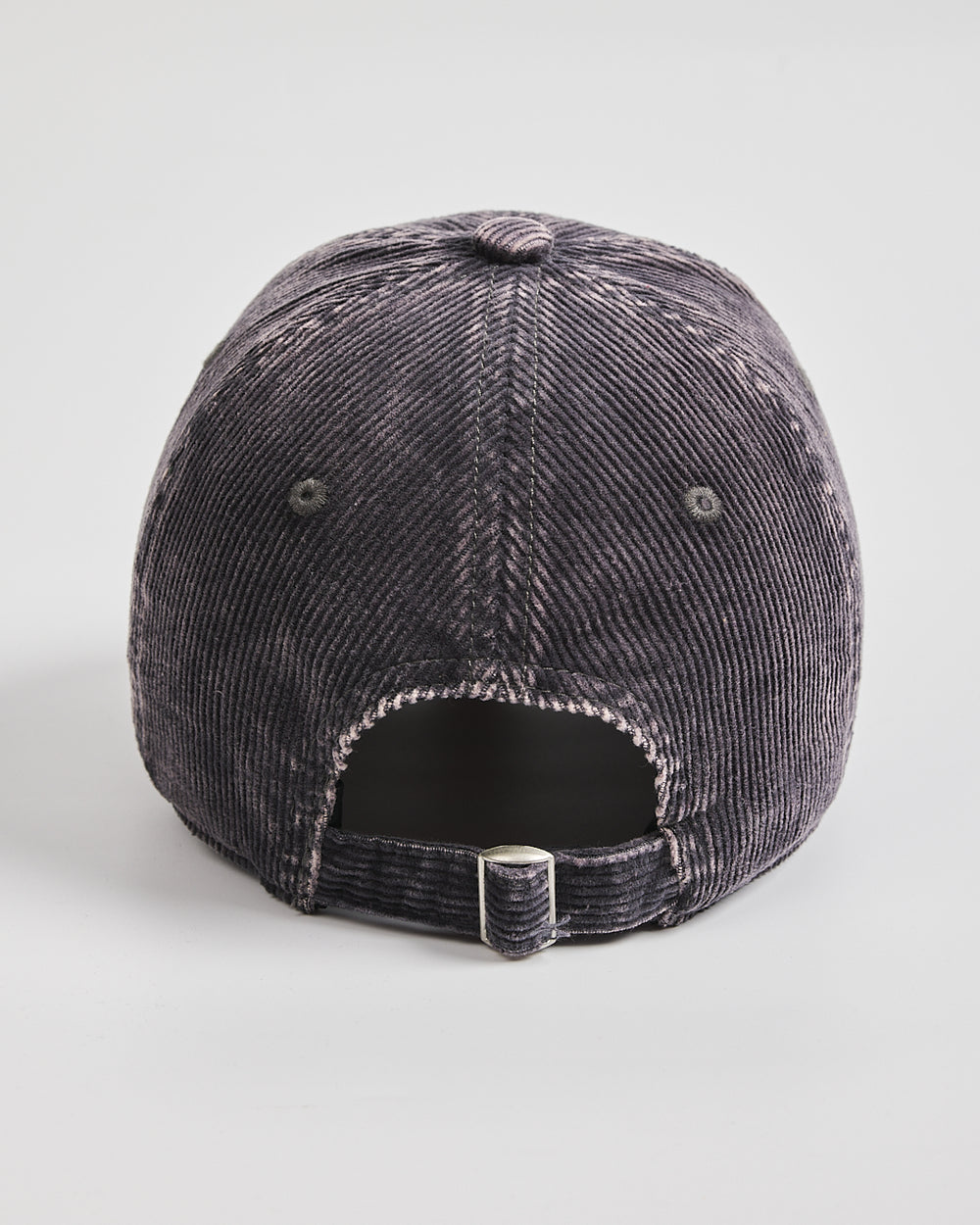 Black corduroy cap on a light gray background