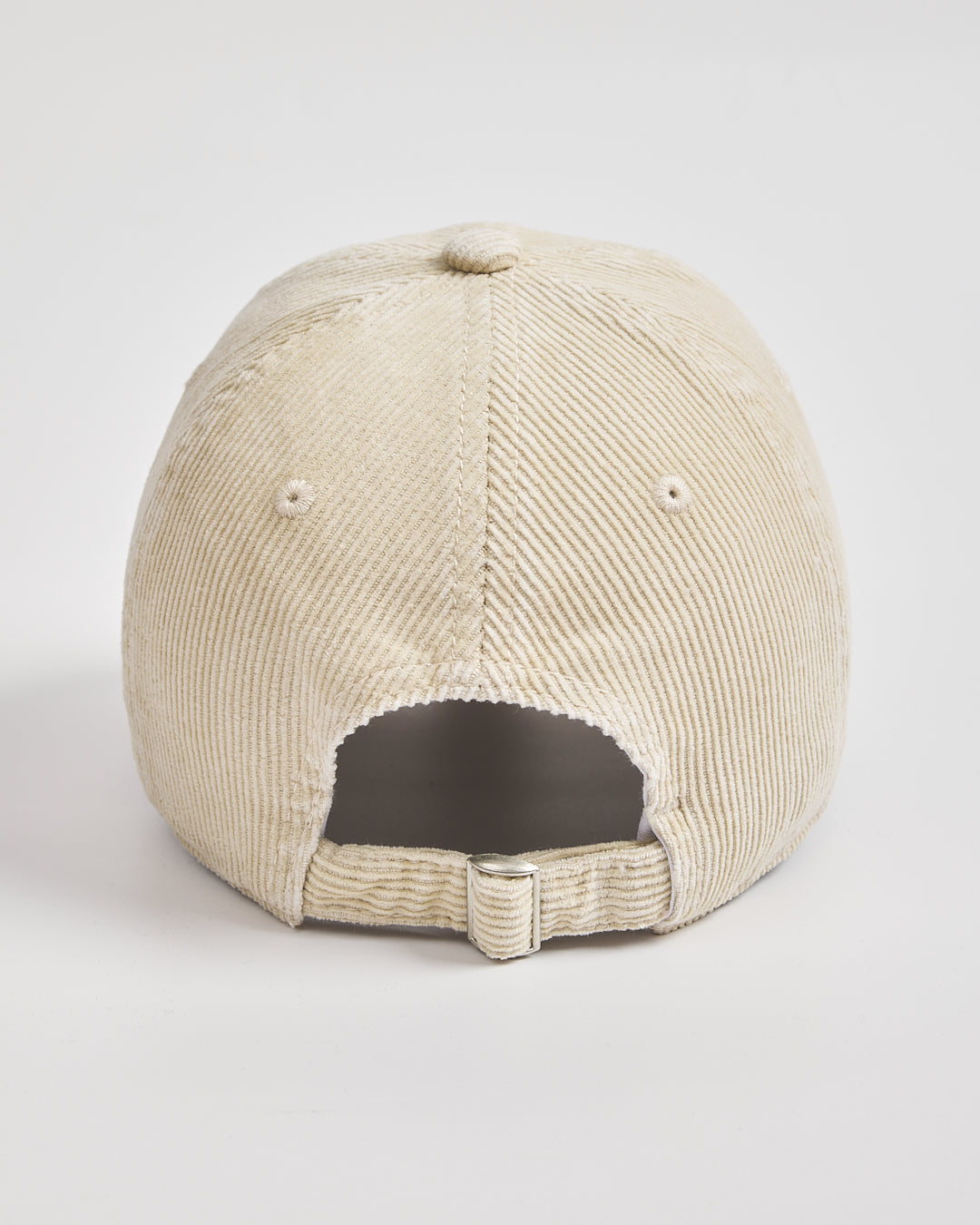 Back view of cream corduroy cap on a light gray background
