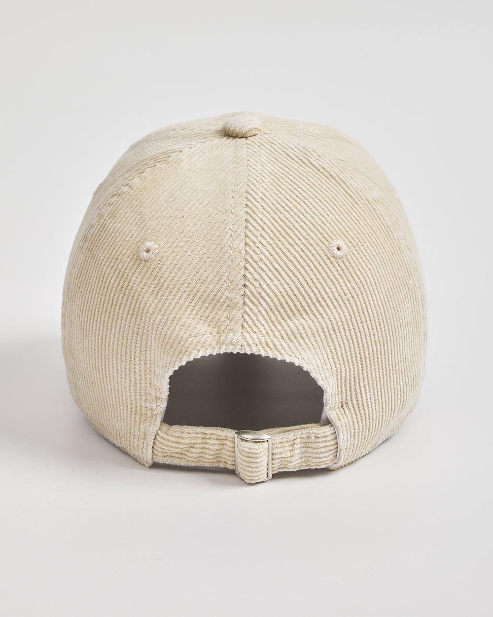 Back view of cream corduroy cap on a light gray background