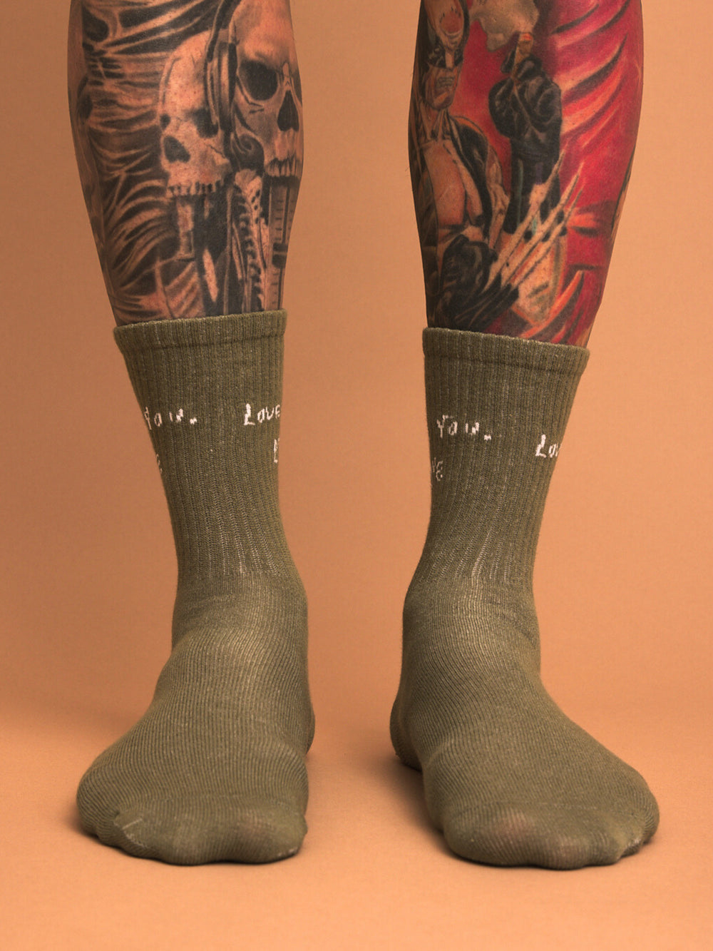 khakisocks worn with tattoos on a beige background