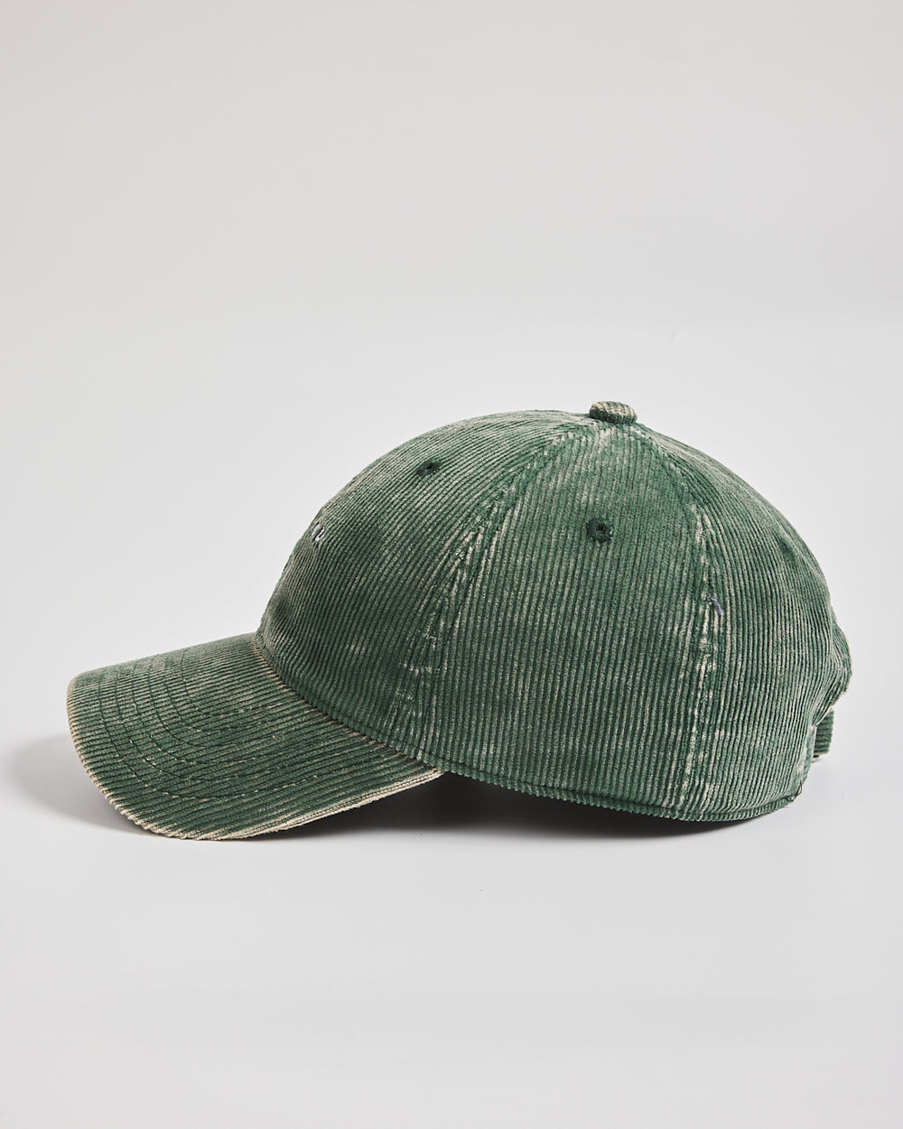 Green corduroy cap on a light gray background