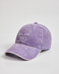 Purple baseball cap with text on a light gray background