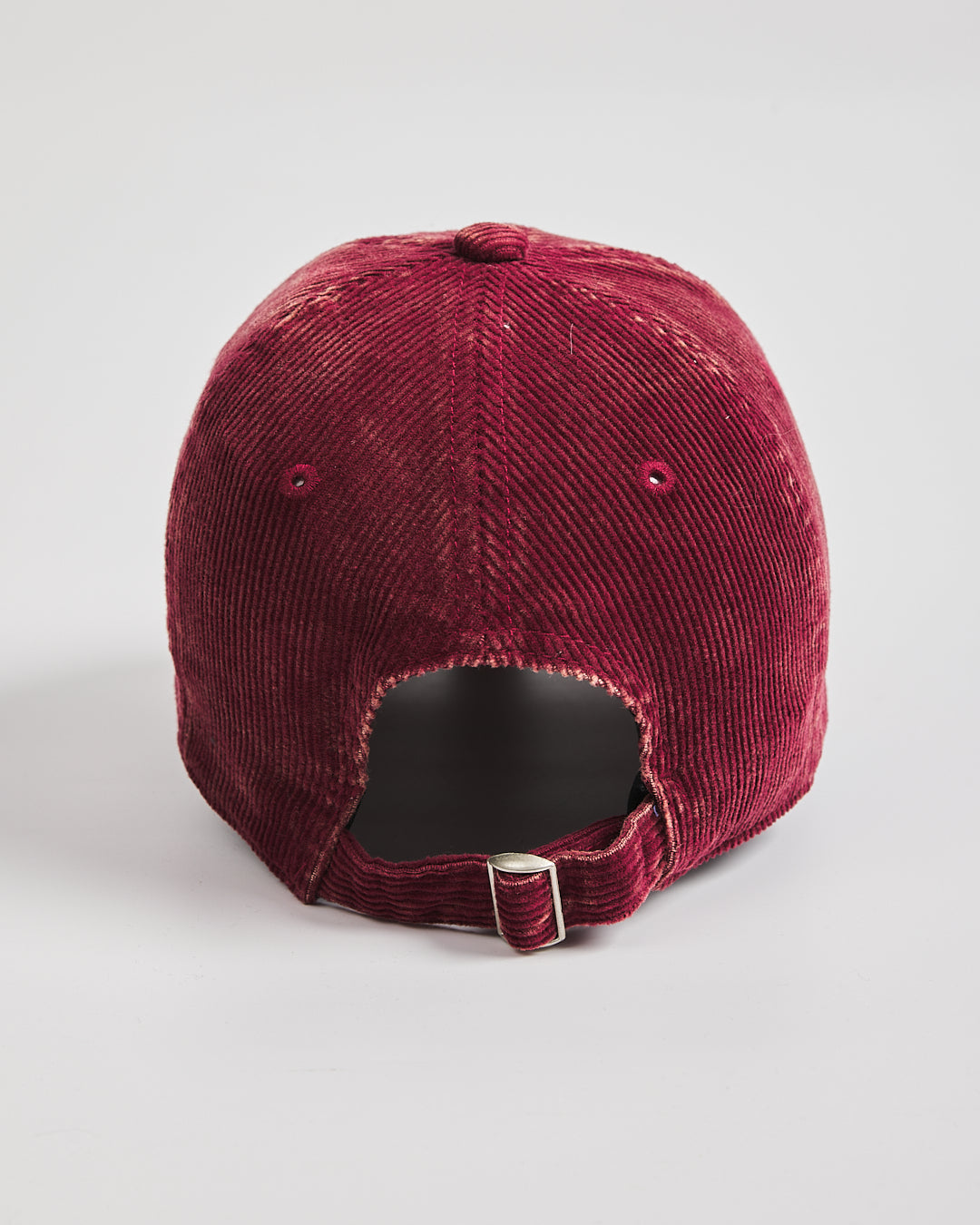 Red corduroy cap on a light gray background