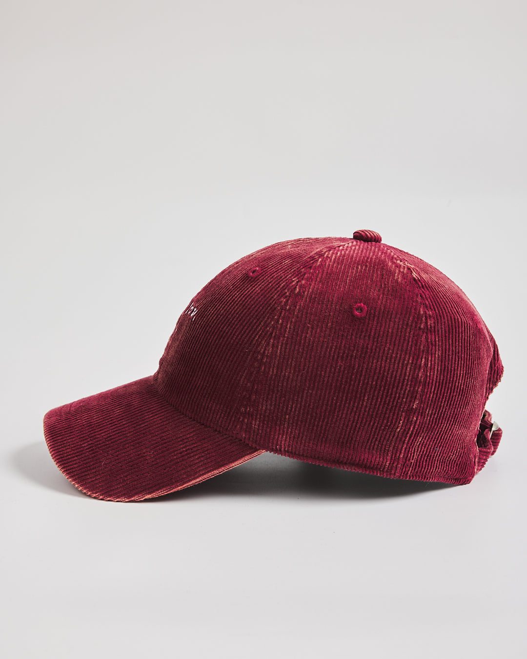 Red corduroy baseball cap on a light gray background