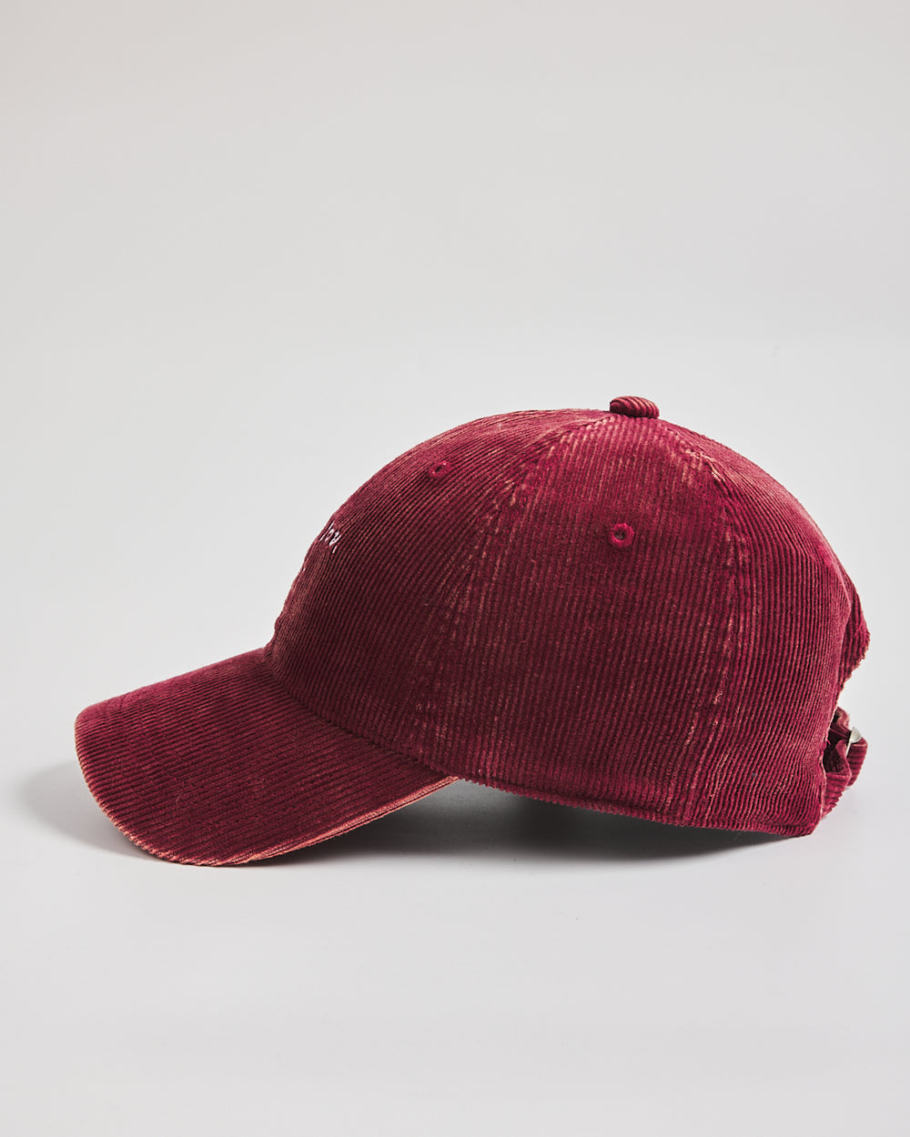 Red corduroy baseball cap on a light gray background