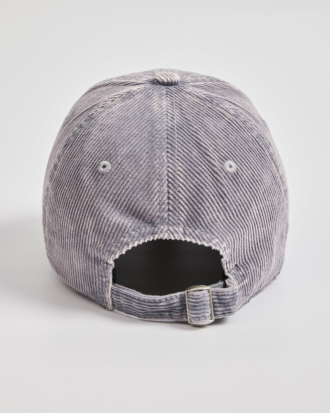 Back view of stone grey corduroy cap on a light gray background