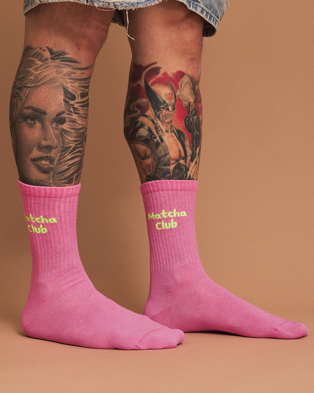 Person wearing pink socks with 'Matcha Club' text on a beige background