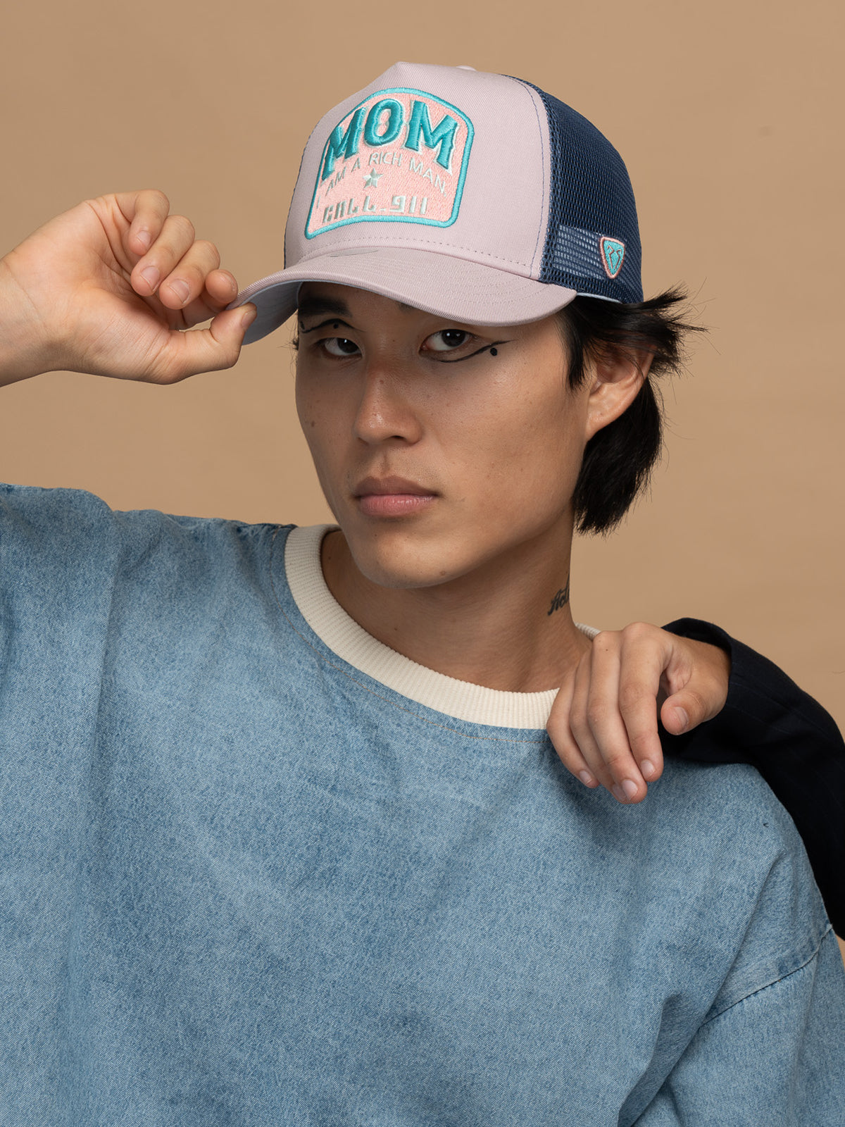 Person wearing Mom Powder Trucker Hat on a beige background