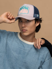 Person wearing Mom Powder Trucker Hat on a beige background