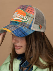 Person wearing Monaco Green Trucker Hat on a beige background
