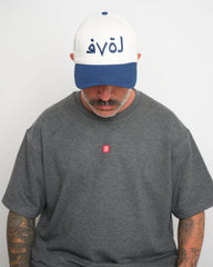 front look of model wearing navy love baseball cap with a grey tee on a white background