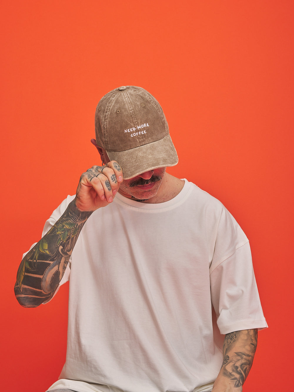 Man wearing a cap with text on an orange background
