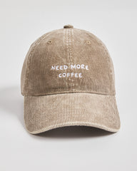 Beige cap with 'Need More Coffee' text on a light gray background
