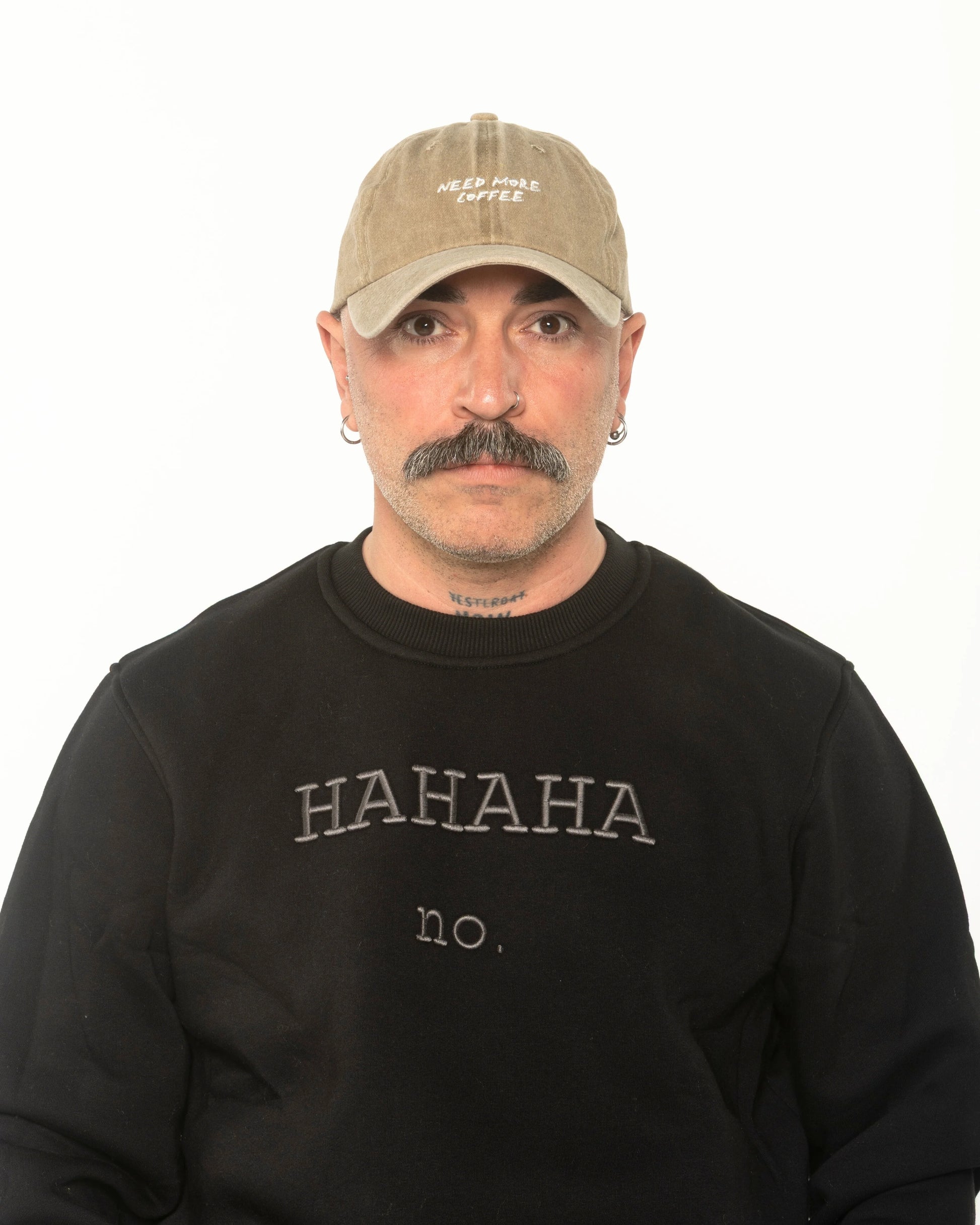 A man wearing the Need More Coffee Beige Washed Cap