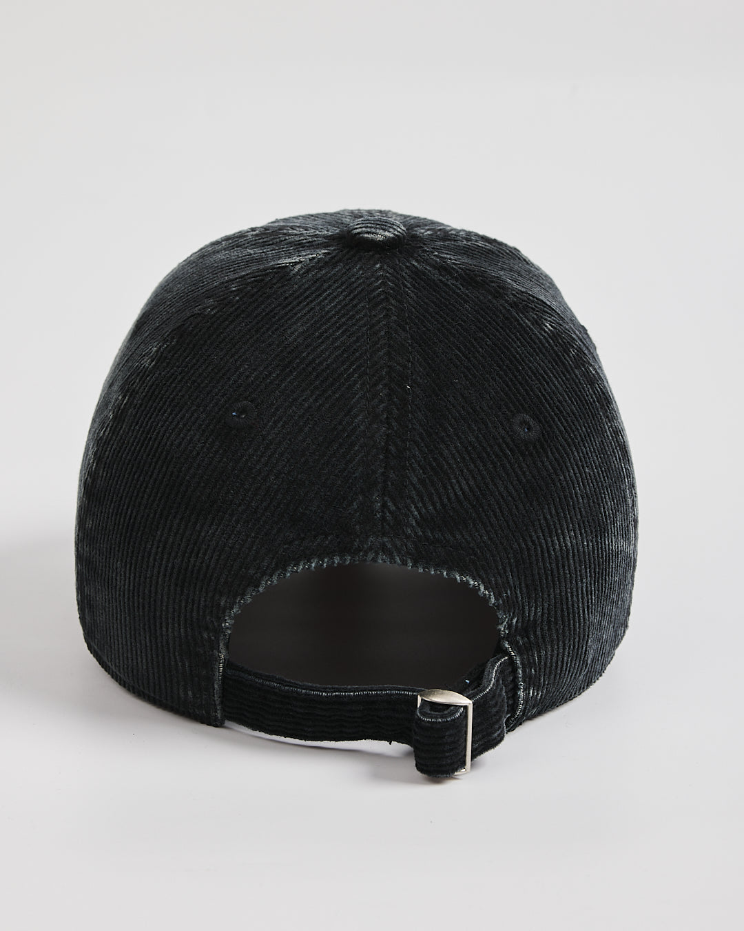 Black corduroy cap on a light gray background