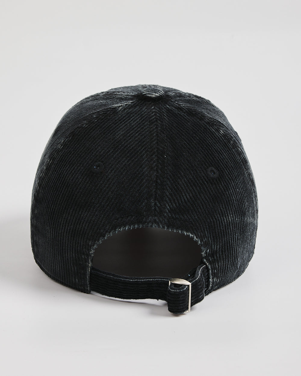 Black corduroy cap on a light gray background