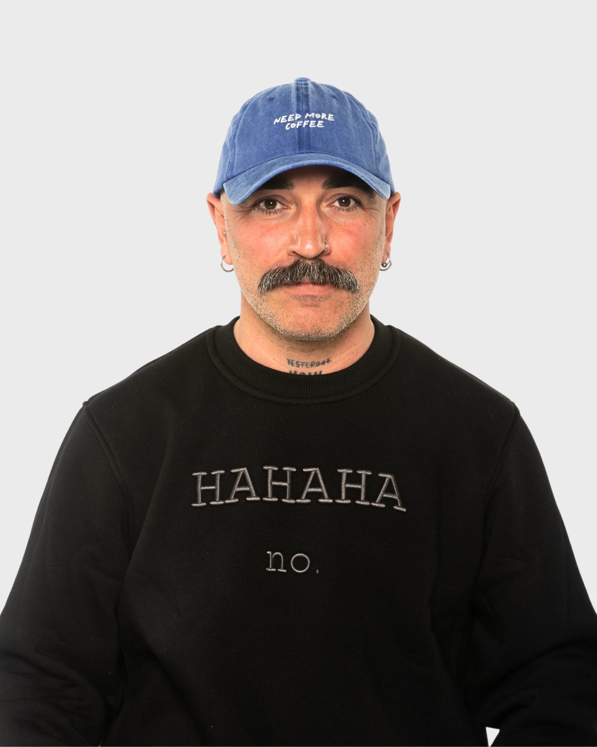 A man wearing the Need More Coffee Blue Washed Cap