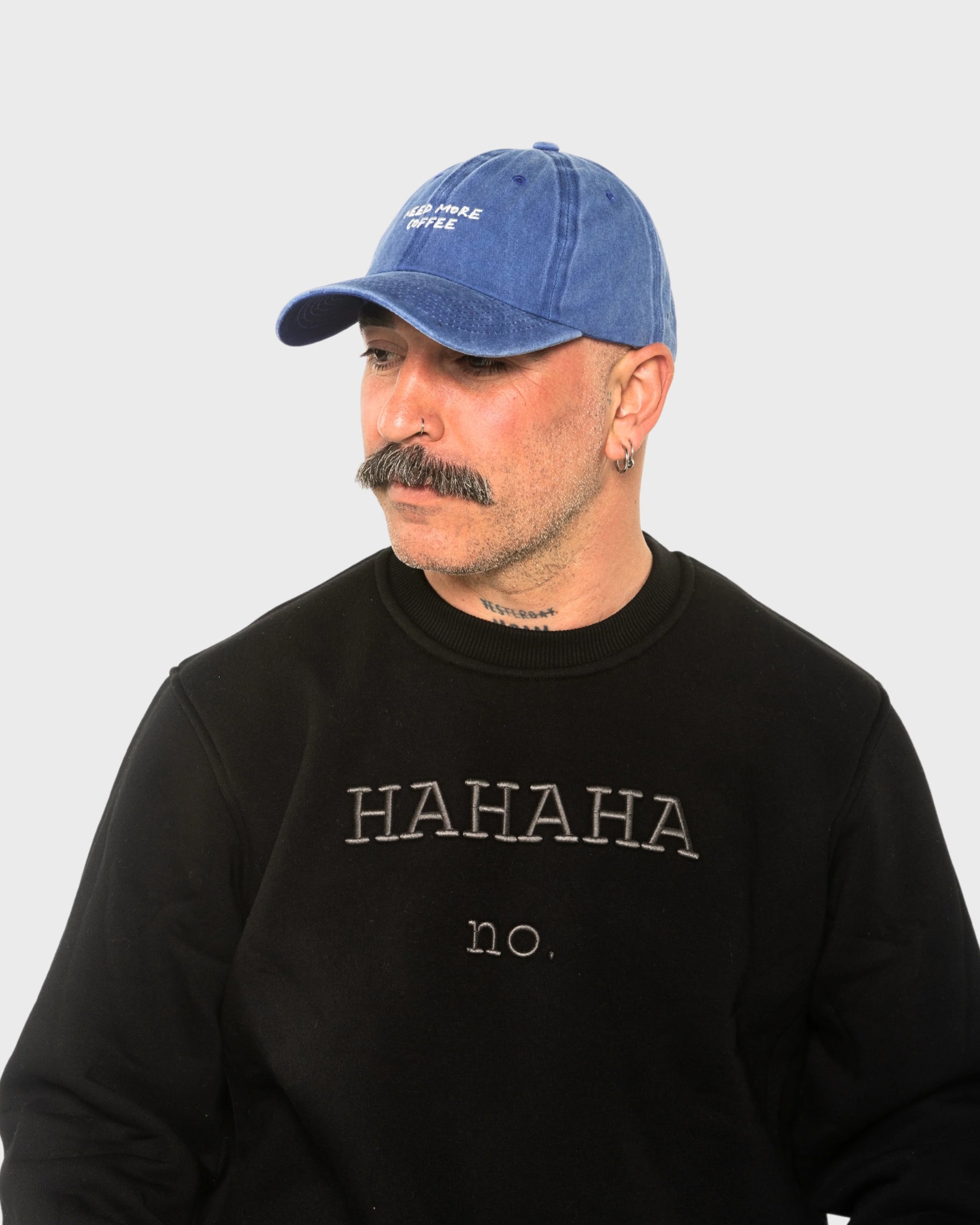 A man wearing the Need More Coffee Blue Washed Cap