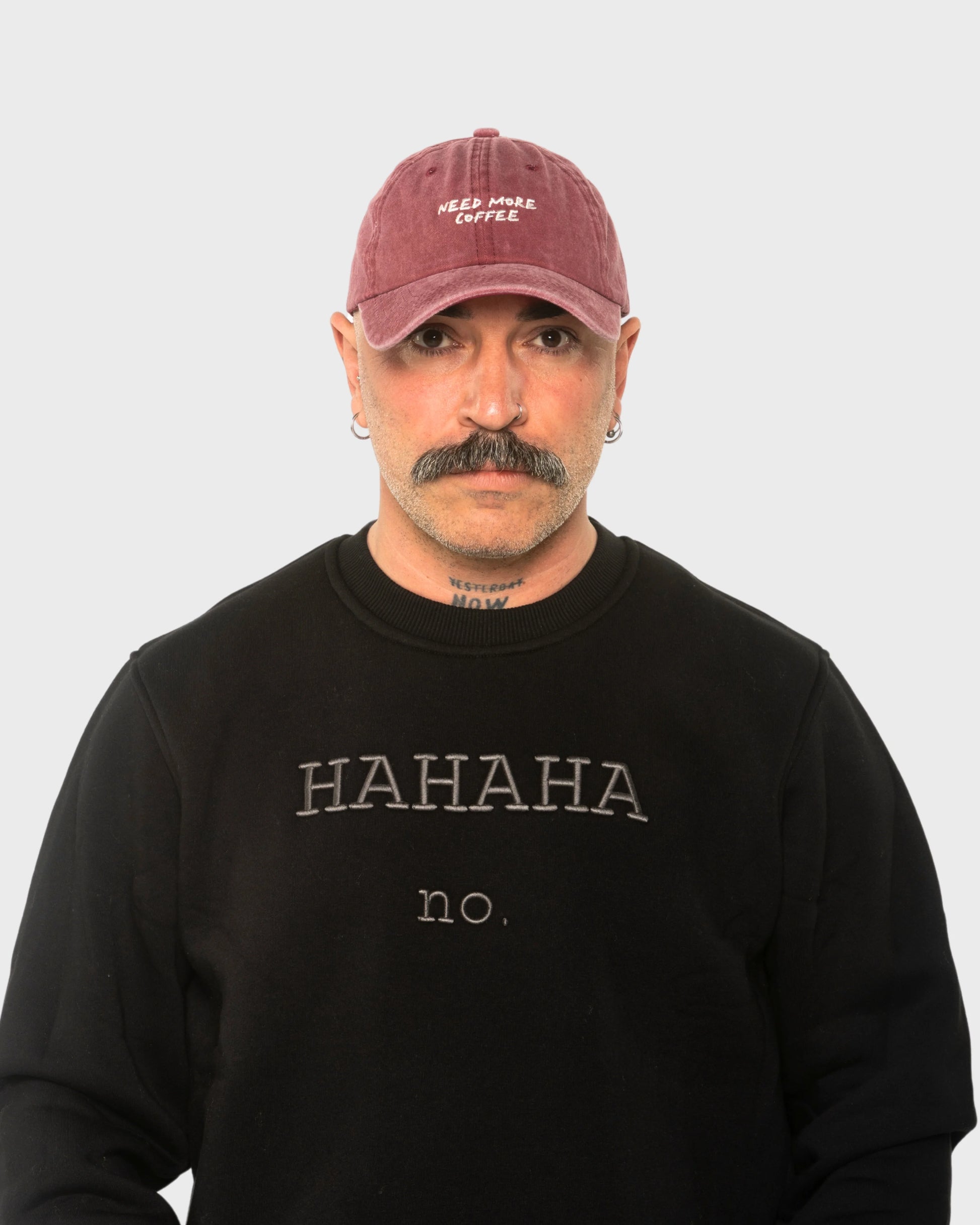 A man wearing the Need More Coffee Burgundy Washed Cap