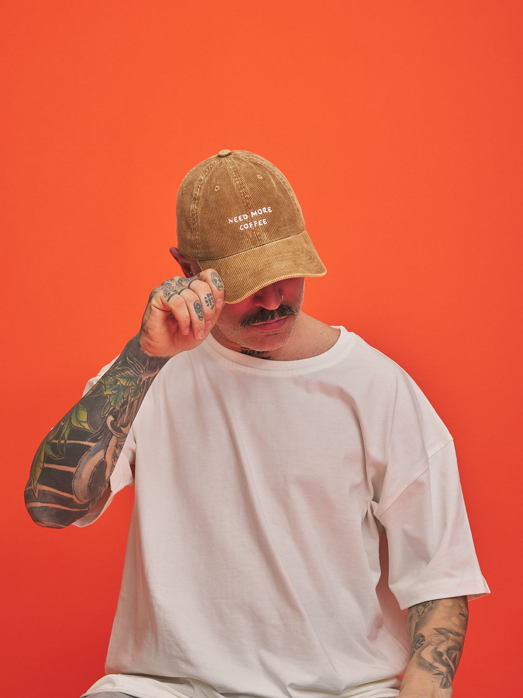Person wearing a camel cap with text on an orange background