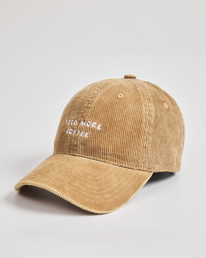 Camel cap with 'Need More Coffee' text on a light gray background