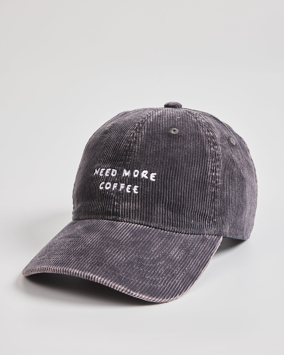 Gray cap with 'Need More Coffee' text on a light gray background