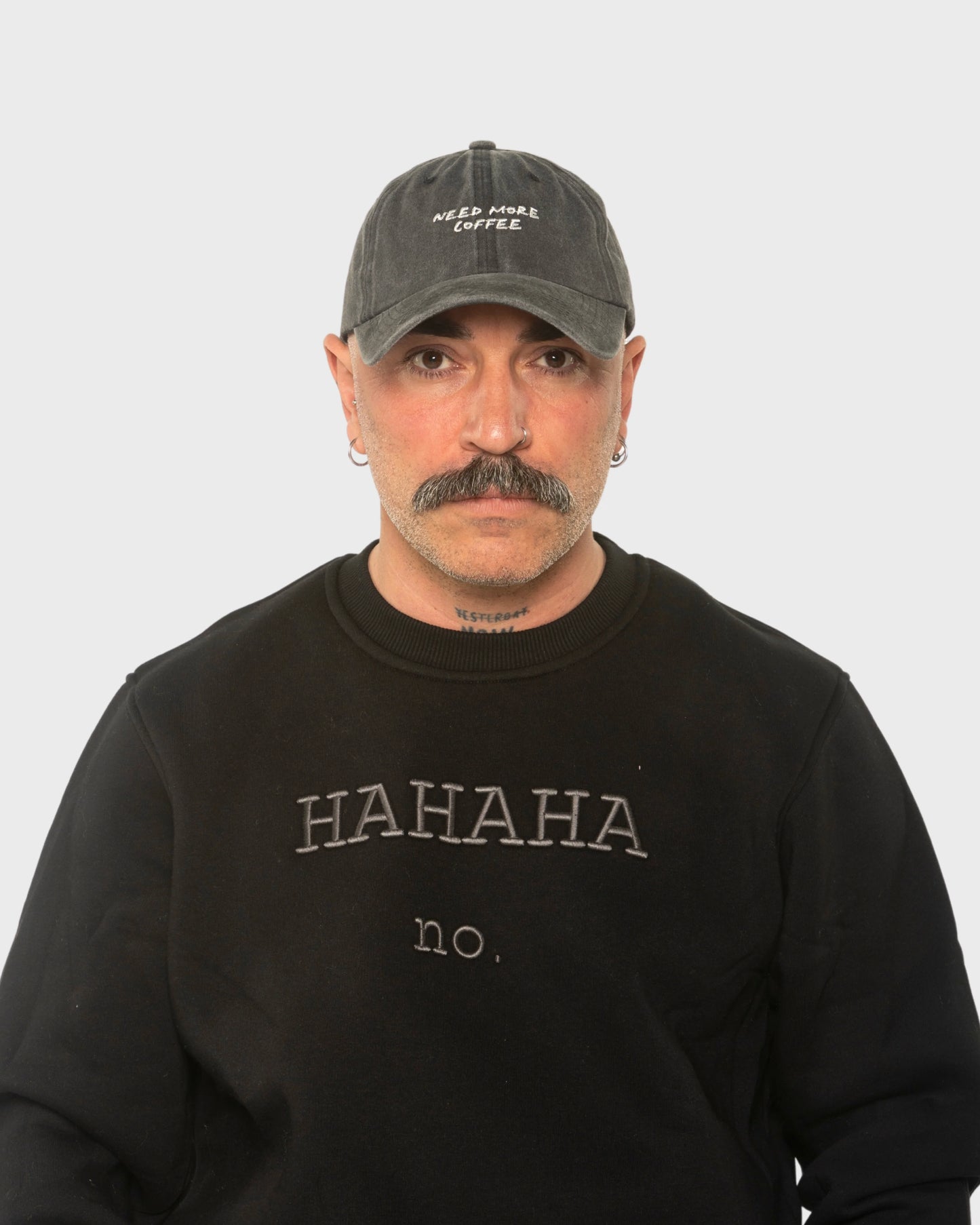 A man wearing the Need More Coffee Dark Grey Washed Cap