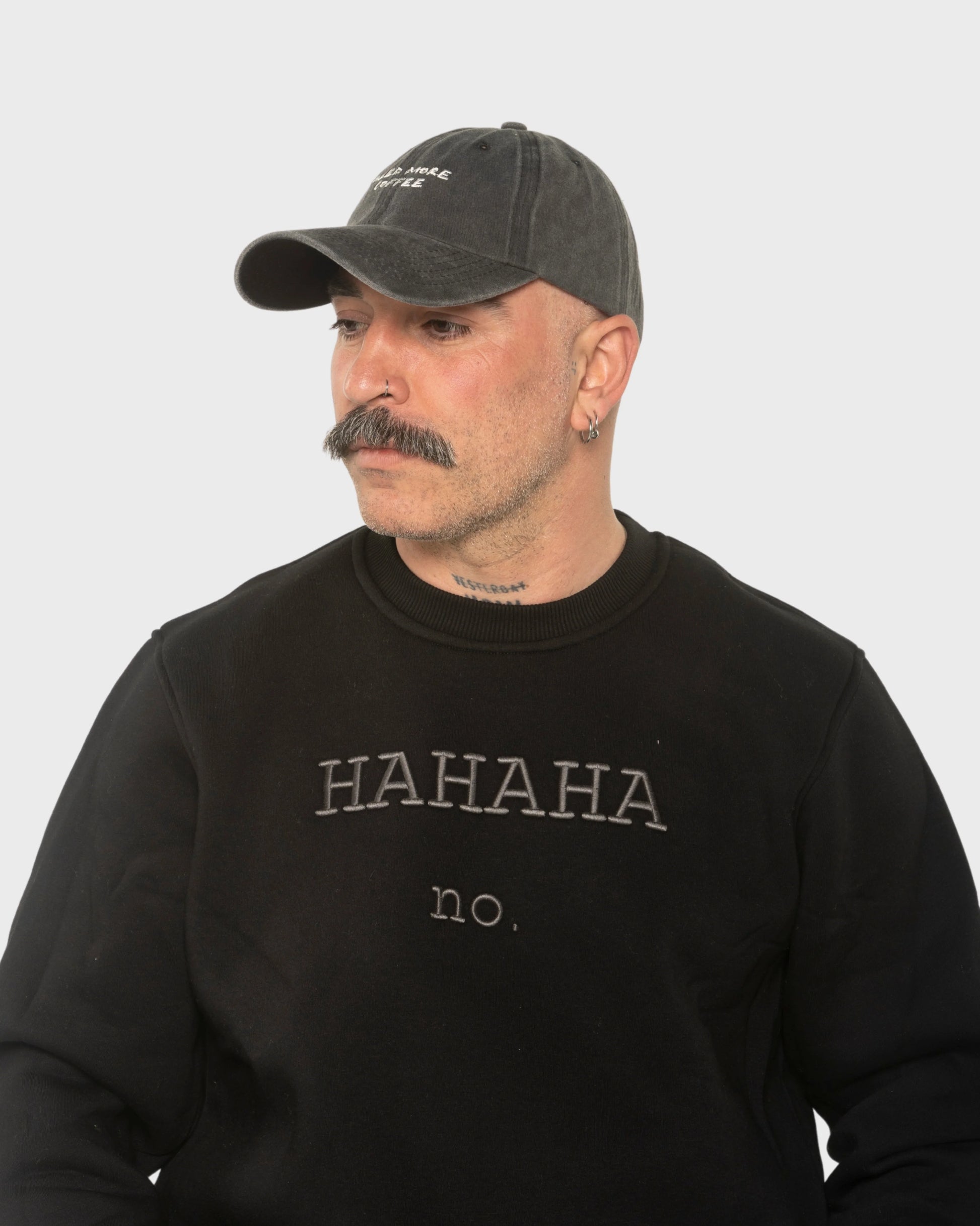 A man wearing the Need More Coffee Dark Grey Washed Cap