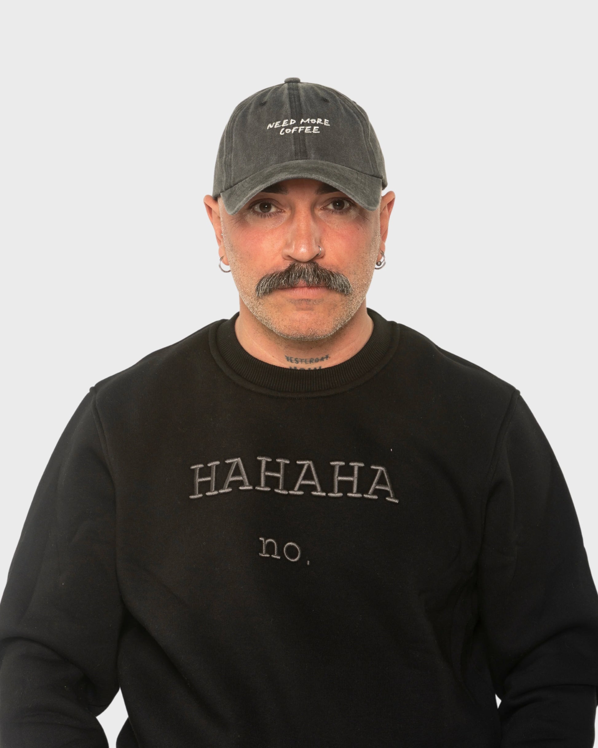 A man wearing the Need More Coffee Dark Grey Washed Cap
