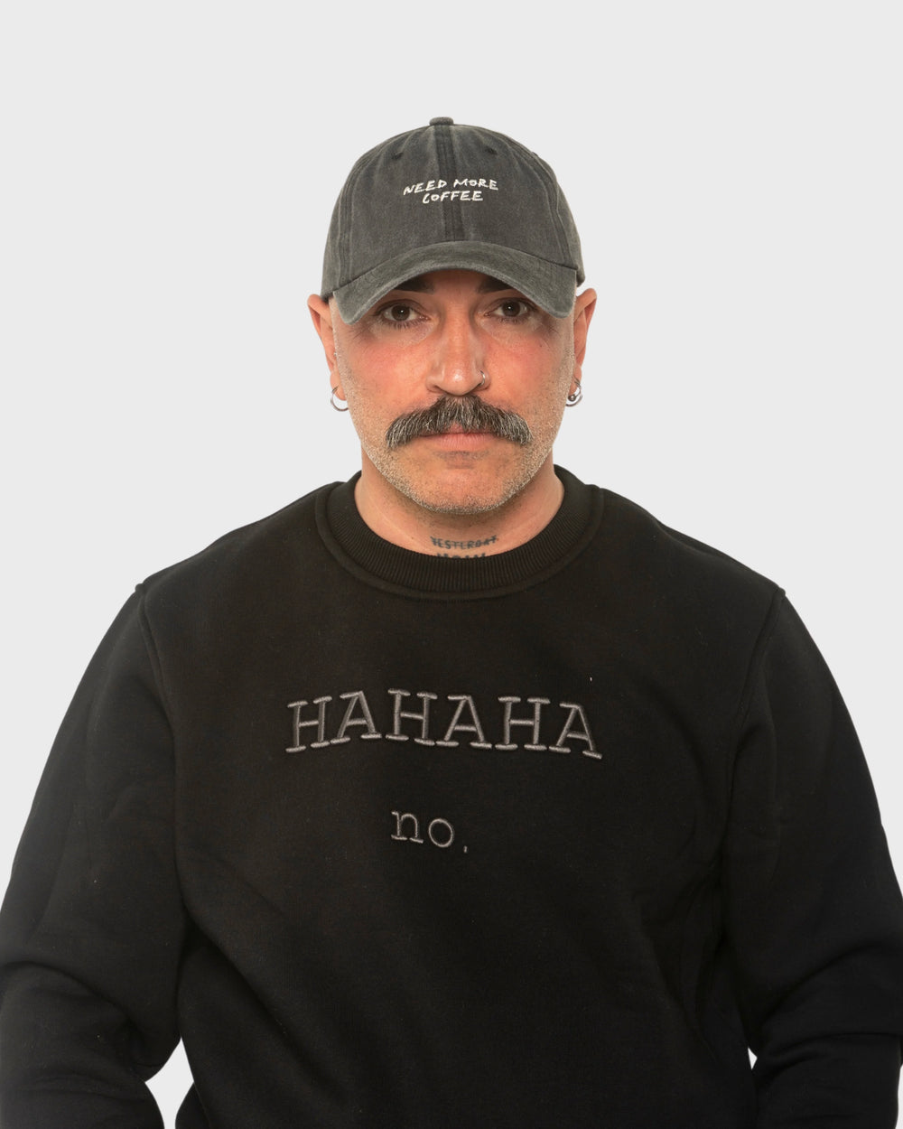 A man wearing the Need More Coffee Dark Grey Washed Cap